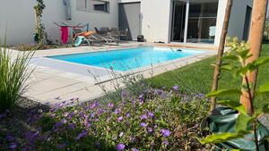 Okolí bazénu zdobí šedý obrubní kámen