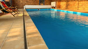 Podél bazénu je nerezová štěrbina pro odtok vody