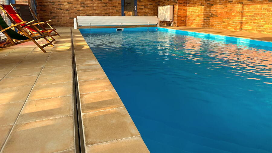 Podél bazénu je nerezová štěrbina pro odtok vody